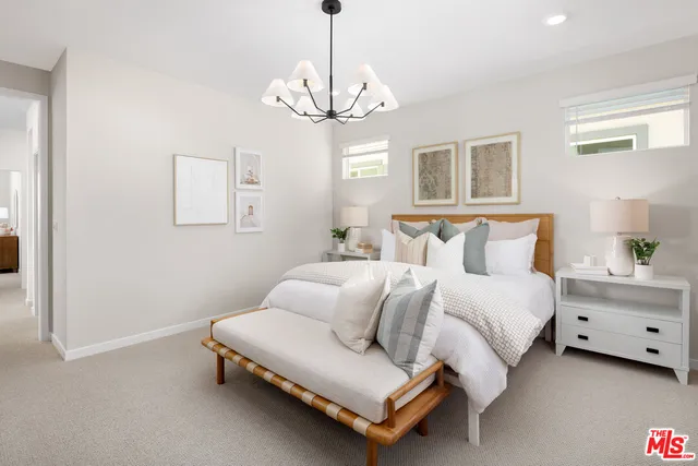 a spacious bedroom with a bed and a chandelier