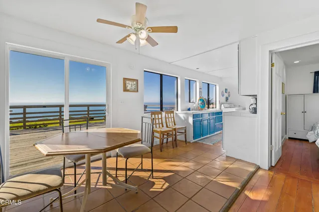 a living room with furniture a large window and stainless steel appliances