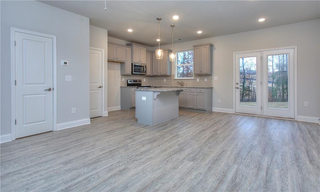106 Greenview Court Cleveland, GA 30528 - Photo 10 of 29 a open kitchen with white cabinets wooden floor and stainless steel appliances