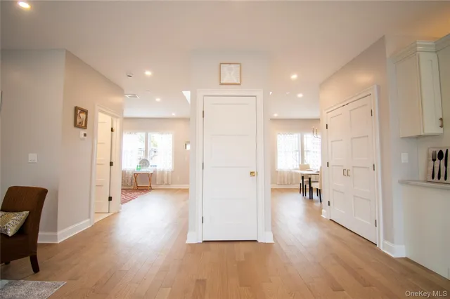 a view of a hallway with wooden floor windows and a living room