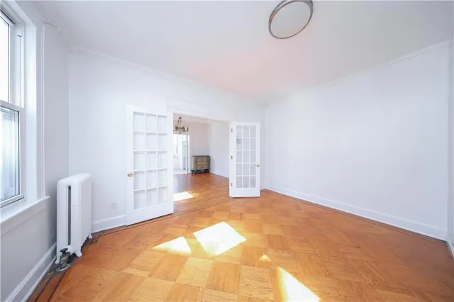 a view of empty room with wooden floor and windows