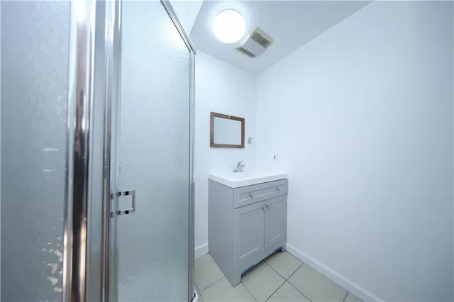 a bathroom with a sink a light fixture and a mirror