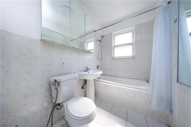 a white toilet sitting next to a bath tub