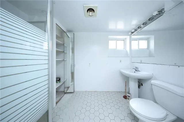 a bathroom with a sink a toilet and mirror