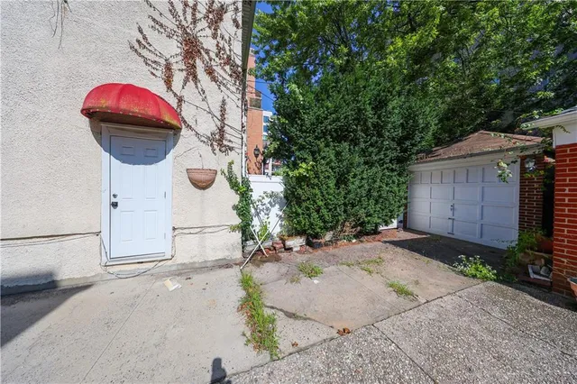 a view of a wooden house with a yard and large tree