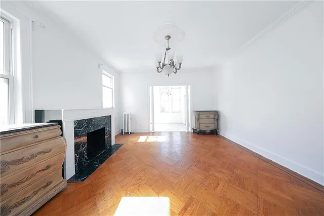 a view of an empty room with a fireplace and window