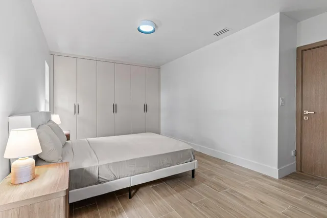 a bedroom with a bed and wooden floor