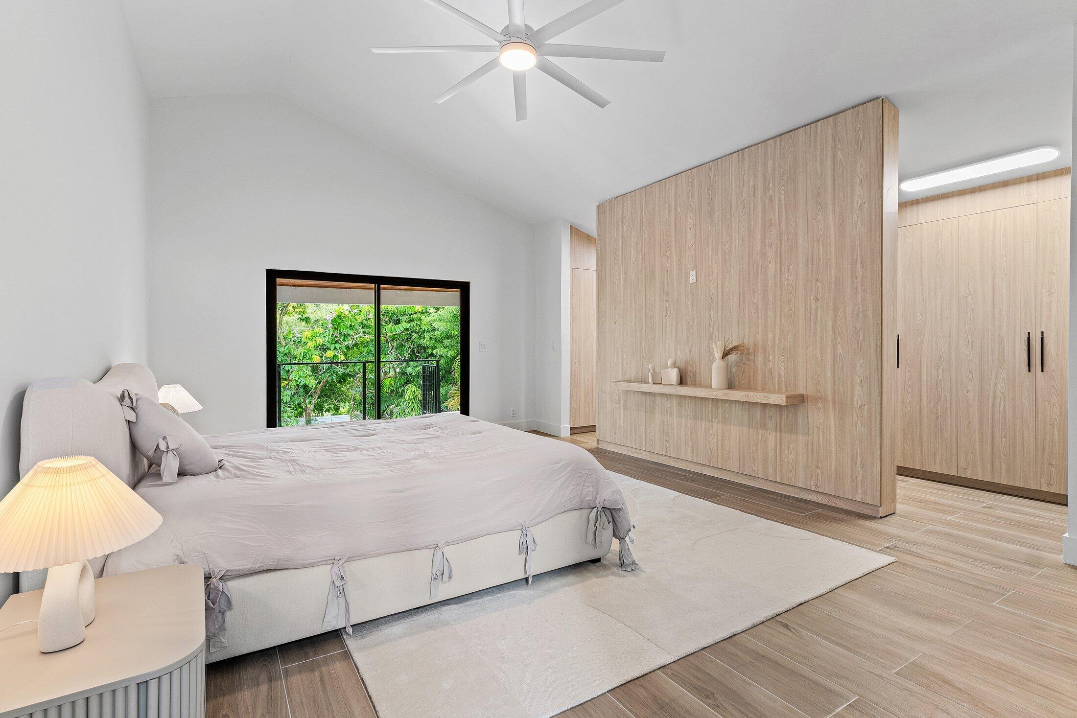 2668 Northwest 41st Street Boca Raton, FL 33434 - Photo 17 of 26 a bedroom with a bed and a chandelier