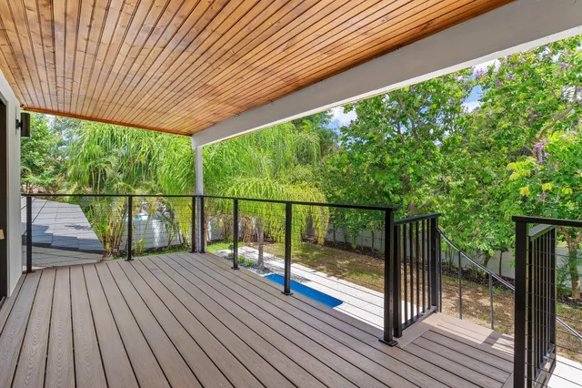 a view of deck with wooden floor and fence with a large garden