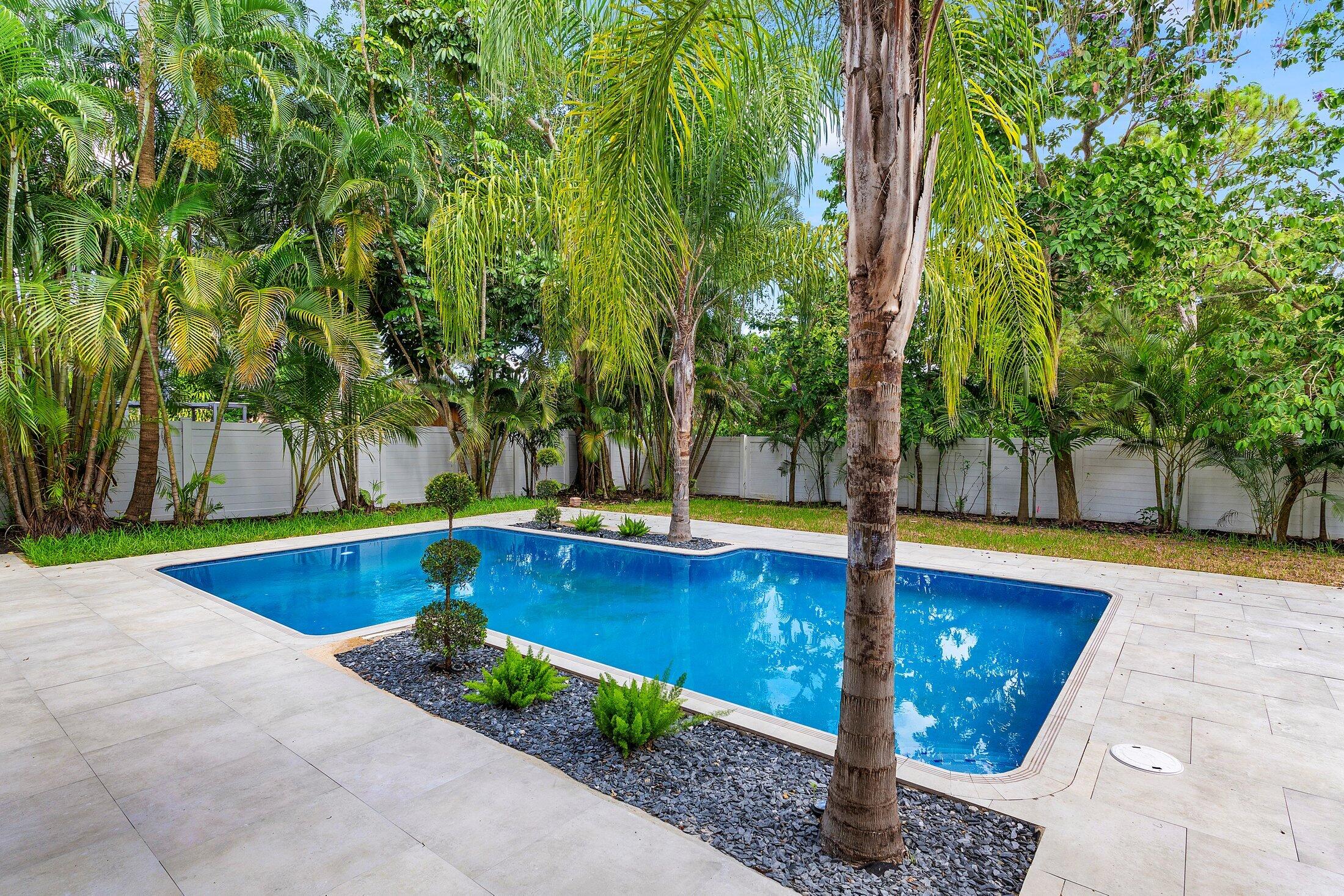 2668 Northwest 41st Street Boca Raton, FL 33434 - Photo 21 of 26 a view of swimming pool with seating area and trees in the background
