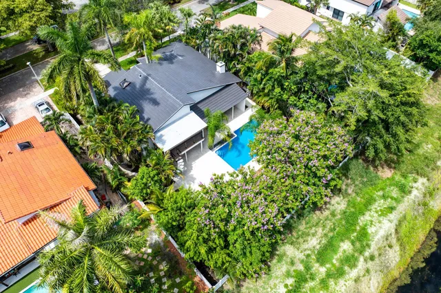 an aerial view of a house with swimming pool and garden space