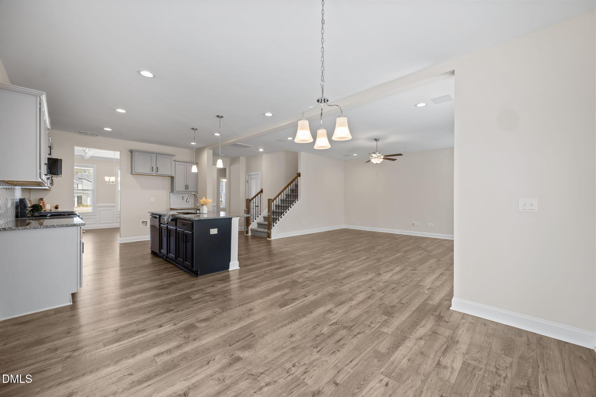 504 Henham Way Zebulon, NC 27597 - Photo 10 of 44 a large room with kitchen island a island a stove a refrigerator and a wooden floor