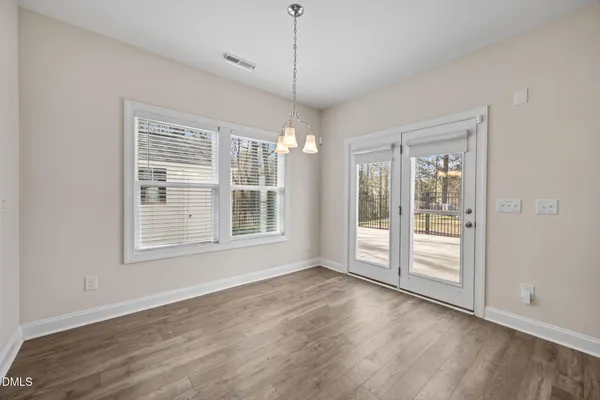 a large room with kitchen island a island a stove a refrigerator and a wooden floor