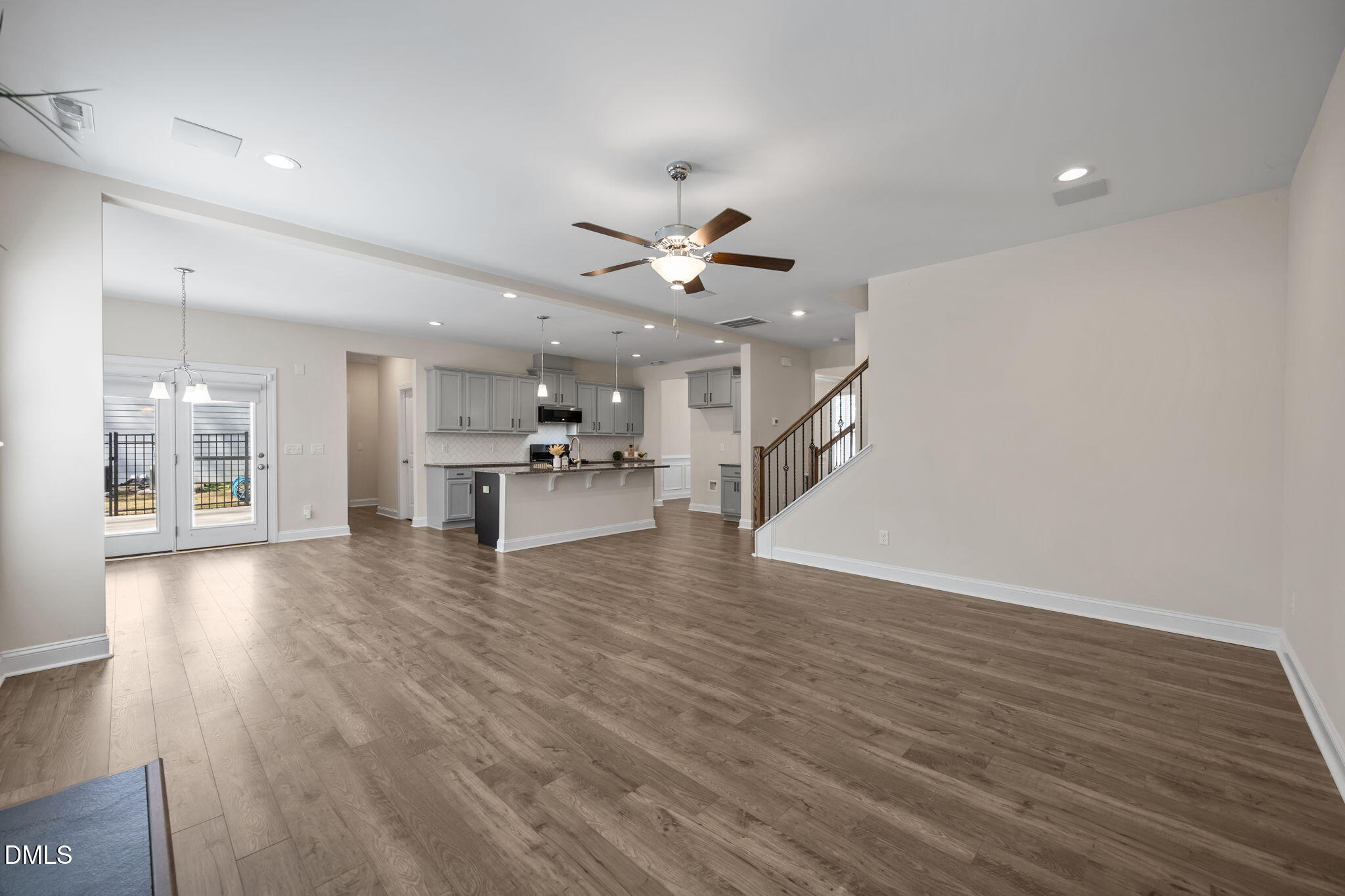 504 Henham Way Zebulon, NC 27597 - Photo 12 of 44 a view of an empty room with wooden floor and a ceiling fan