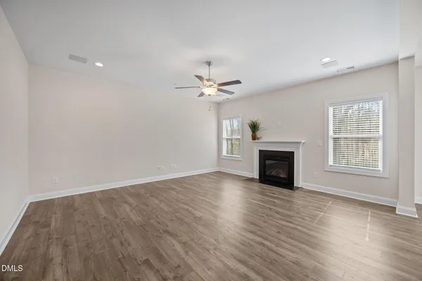 a view of an empty room with a fireplace and a window