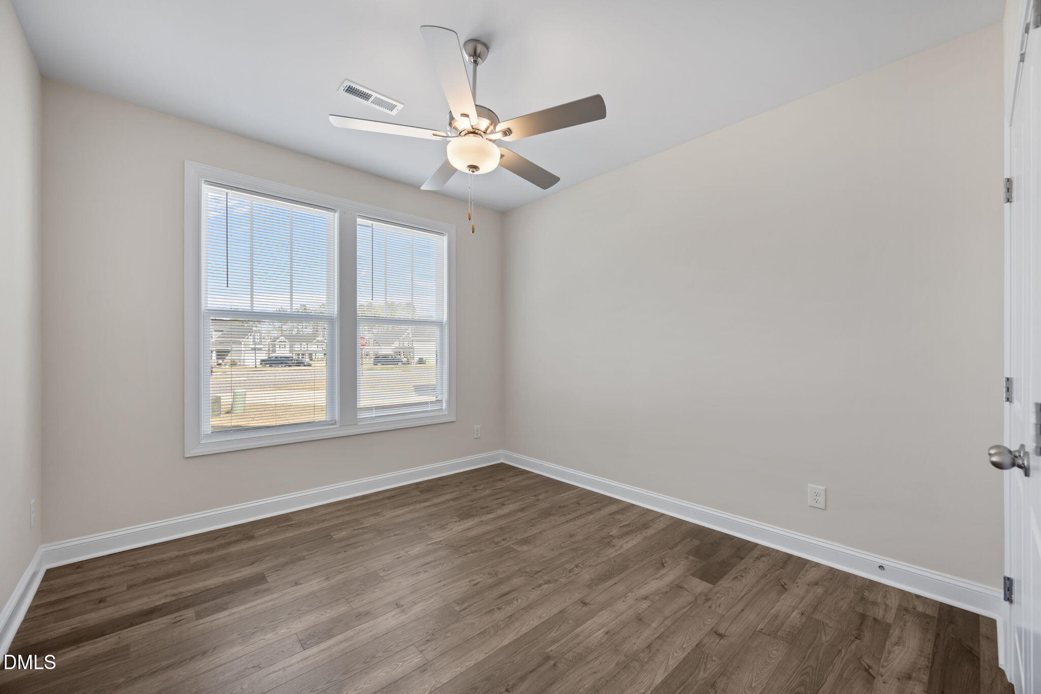 504 Henham Way Zebulon, NC 27597 - Photo 16 of 44 an empty room with wooden floor fan and windows