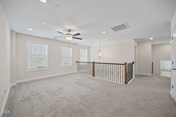 an empty room with windows and fan