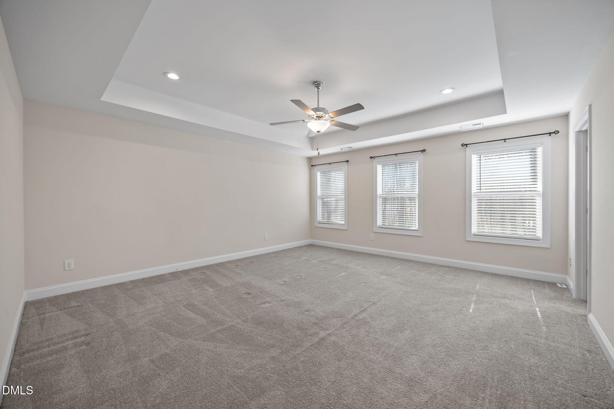 504 Henham Way Zebulon, NC 27597 - Photo 21 of 44 an empty room with chandelier fan and windows