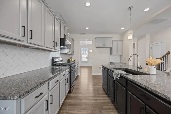 a kitchen with stainless steel appliances sink stove top oven and cabinets
