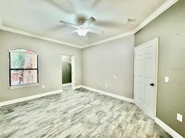 a view of an empty room with window and wooden floor
