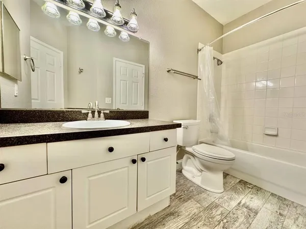 a bathroom with a toilet a sink a mirror and shower