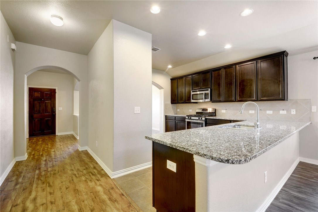 a kitchen with granite countertop a sink and counter top space