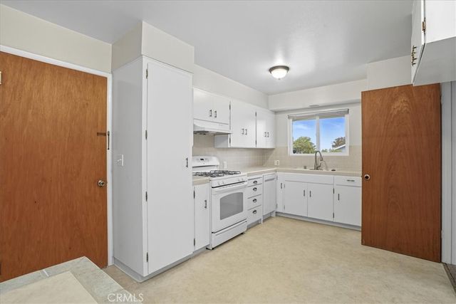 a kitchen with cabinets appliances and a window