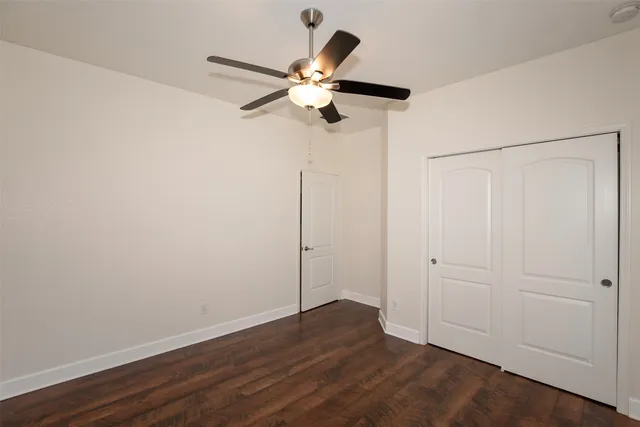 a view of a room with wooden floor closet and chandelier fan