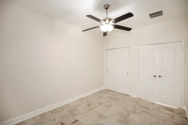an empty room with a window and a fan