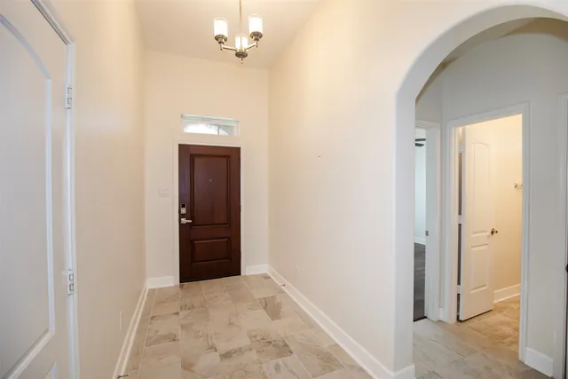 a view of a hallway with a chandelier fan