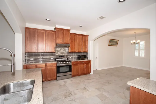 a kitchen with stainless steel appliances granite countertop a sink stove and cabinets