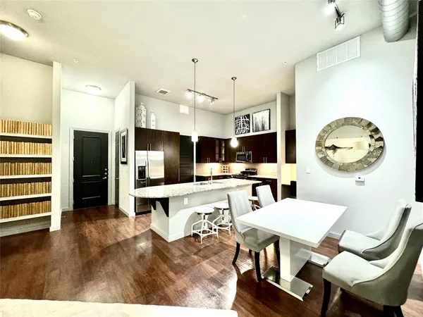 a living room with furniture a flat screen tv and kitchen view