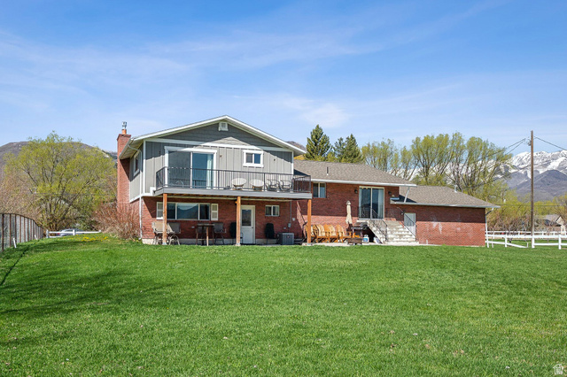 550 Pine Canyon Road Midway, UT 84049 - Photo 2 of 44 Spacious backyard featuring a large green lawn, a multi-level deck, and a balcony with black metal railing