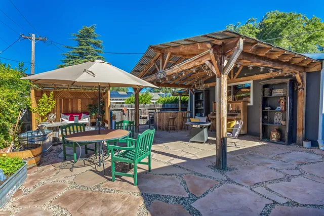 a view of a patio with table and chairs potted plants with wooden floor and seating space