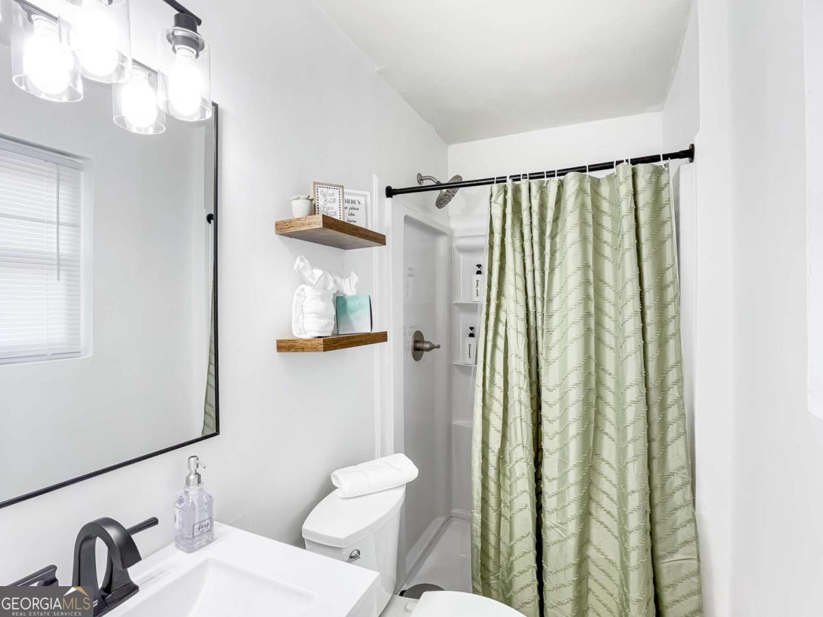 1224 Crawford Way Pooler, GA 31322 - Photo 11 of 12 a bathroom with a sink a mirror a toilet and shower