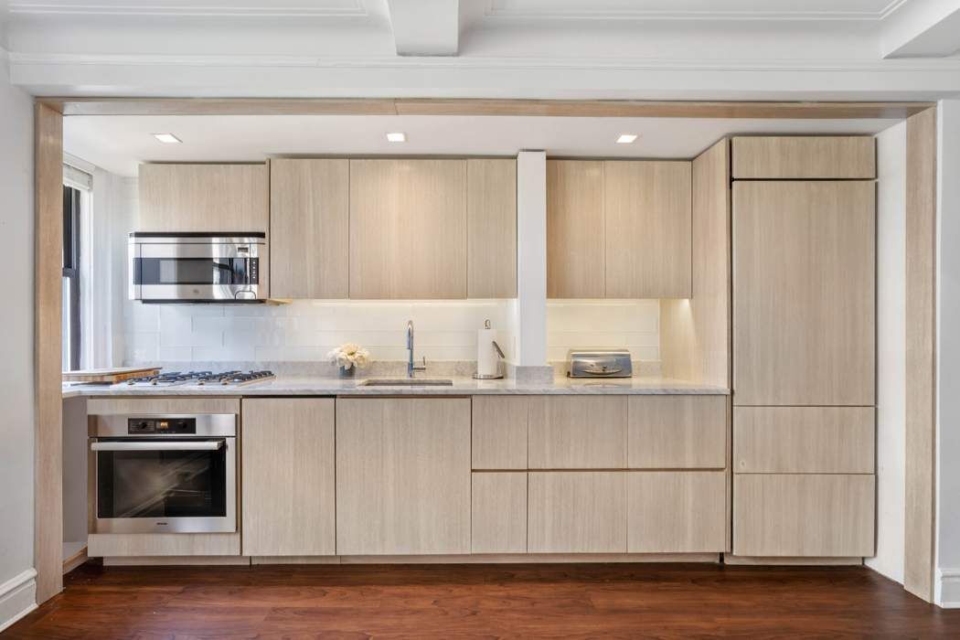 333 East 53rd Street, Unit 5B Manhattan, NY 10022 - Photo 1 of 12 a kitchen with stainless steel appliances granite countertop a stove a sink and white cabinets
