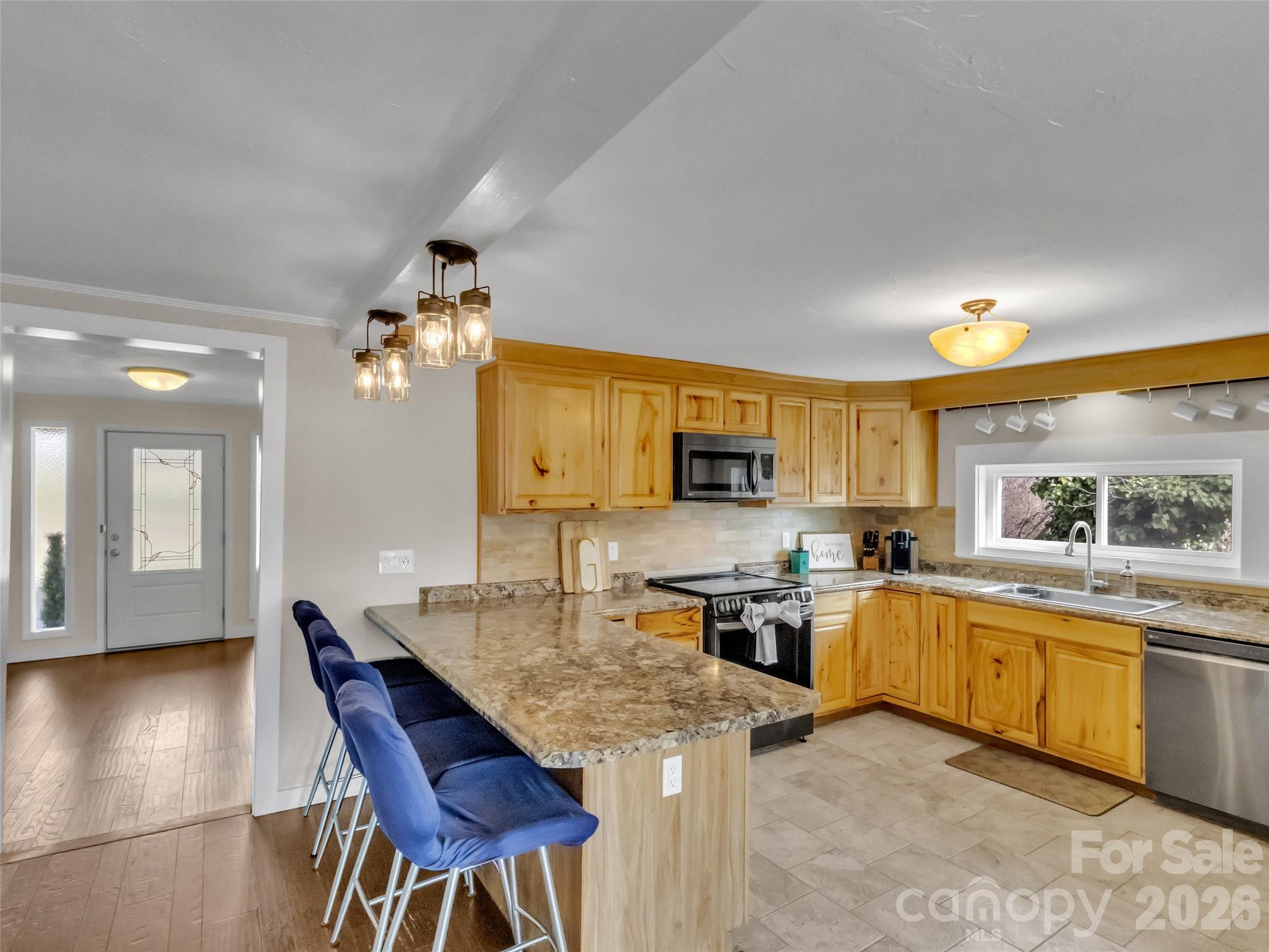 43 Melton Road Candler, NC 28715 - Photo 12 of 44 a kitchen with stainless steel appliances granite countertop table chairs sink and cabinets