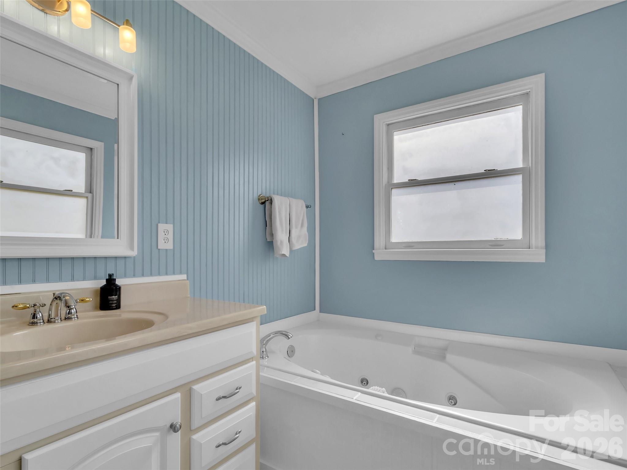 43 Melton Road Candler, NC 28715 - Photo 16 of 44 a bathroom with a bathtub sink and mirror