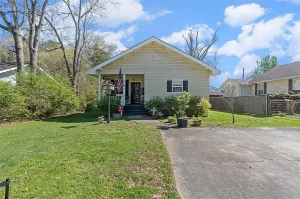 a view of a house with backyard and trees