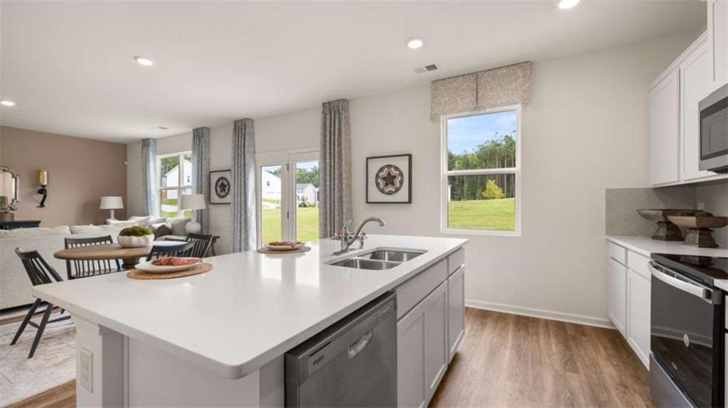 318 Friendship Oak Way Hampton, GA 30228 - Photo 10 of 41 a kitchen with stainless steel appliances granite countertop a sink a stove and a refrigerator