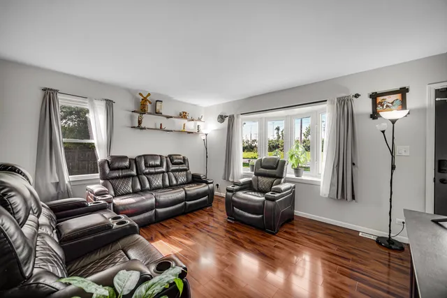 a living room with furniture floor to ceiling window and a flat screen tv
