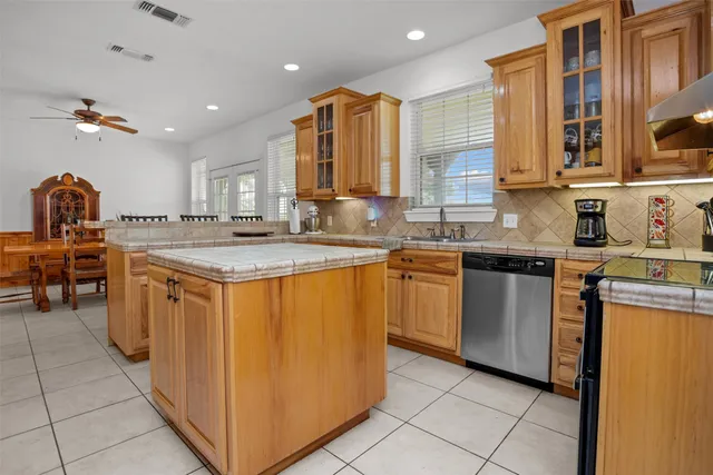 a kitchen with stainless steel appliances granite countertop a sink counter space cabinets and a large window