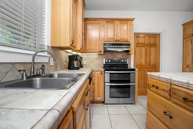 a kitchen with granite countertop a stove and a sink