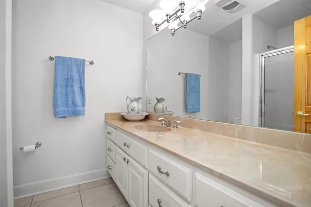 a bathroom with a granite countertop sink a mirror and vanity