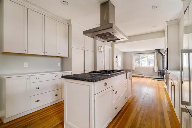 a kitchen with stainless steel appliances a stove a sink and white cabinets