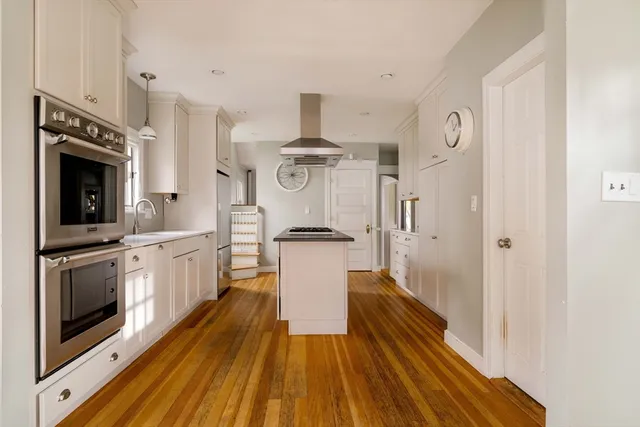 a kitchen with a refrigerator a stove and wooden cabinets