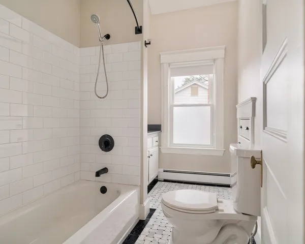 a bathroom with a granite countertop toilet a sink and a bathtub