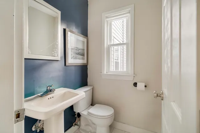 a bathroom with a toilet a sink and a mirror