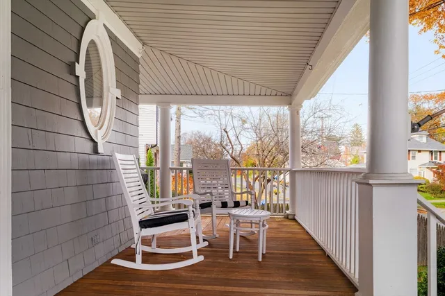a balcony view with couple of chairs and wooden floor