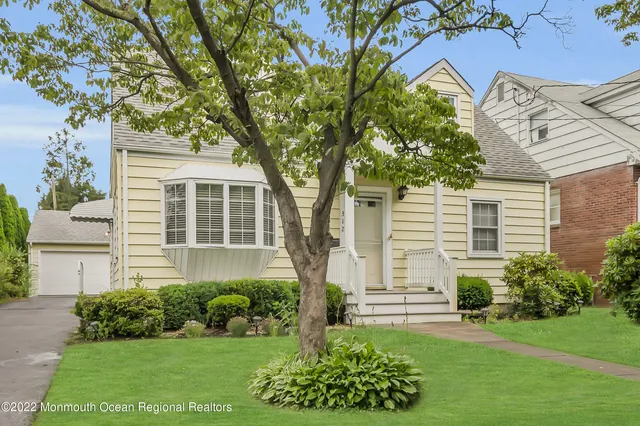 a front view of a house with a garden and plants